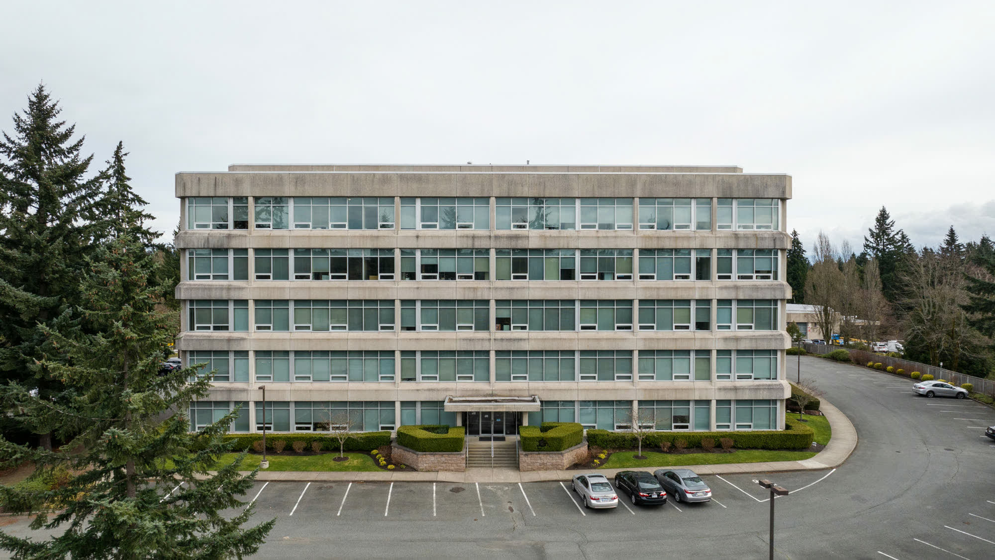 A four-story suburban office building on a landscaped campus