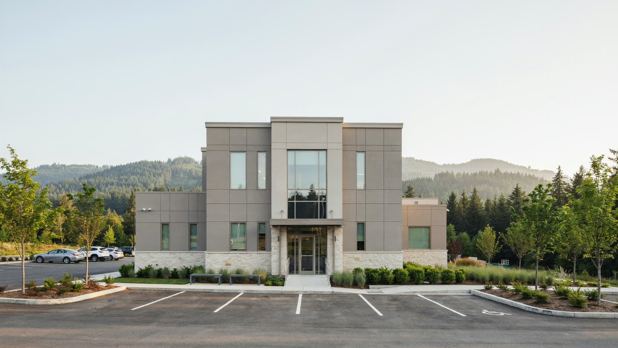 A two-story medical office building with a covered entrance and landscaped parking