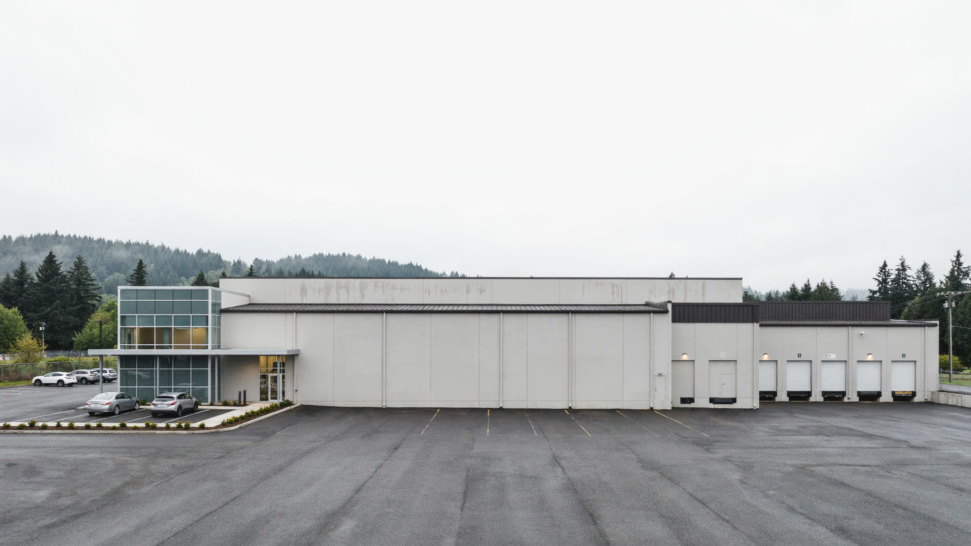 A modern distribution warehouse with loading docks and a glass office entrance